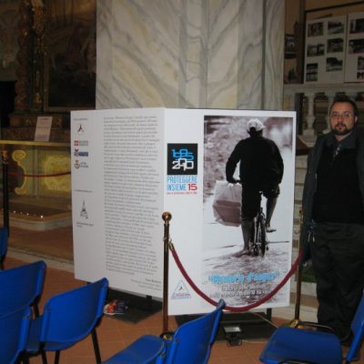 Luca in front of the panel of the exhibition.